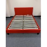 A boxed 5' red leather bed frame