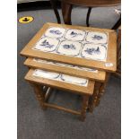 A nest of three tiled oak tables