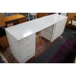 A laminated white four drawer chest and matching desk