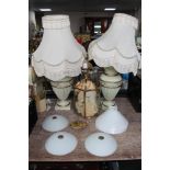 A brass ceiling light together four lamp shades and a pair of table lamps