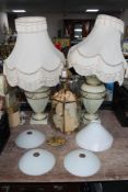 A brass ceiling light together four lamp shades and a pair of table lamps