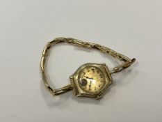 A lady's 14ct gold cased wristwatch on yellow metal expanding strap,