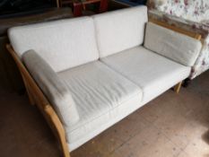 A beech framed two seater settee in oatmeal colour fabric.