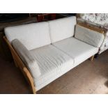 A beech framed two seater settee in oatmeal colour fabric.