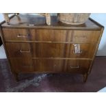 A mid century walnut four drawer chest.