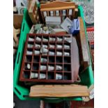 A crate of thimbles and thimble stands