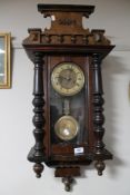 A Victorian stained beech wood wall clock with pendulum