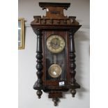 A Victorian stained beech wood wall clock with pendulum