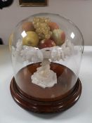 An antique glass dome on mahogany plinth containing a marble pedestal stand with fruit