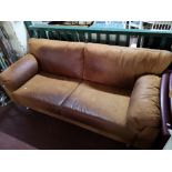 A tan leather three seater settee.