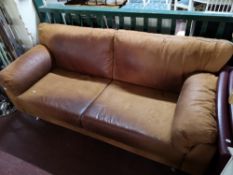 A tan leather three seater settee.