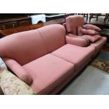 An antique style two seater settee and armchair upholstered in pink with scatter cushions