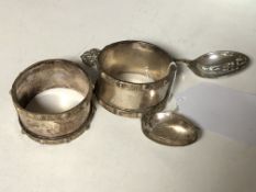 A pair of Lindisfarne silver napkin rings and a boxed pair of spoons depicting St.