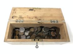 A wooden box with key containing a large quantity of Victorian and later coins