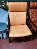 A Scandinavian armchair in tan leather.