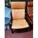 A Scandinavian armchair in tan leather.
