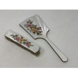 A two piece floral enamel and silver mirror and brush set