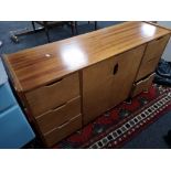 A multi drawer double door teak sideboard