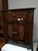 A reproduction oak corner cabinet