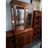 A reproduction yewwood glazed bookcase