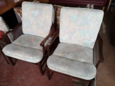 A pair of mid century armchairs in studded fabric.