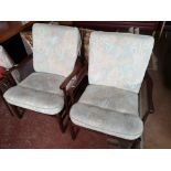 A pair of mid century armchairs in studded fabric.