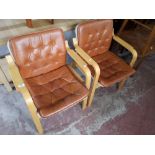 A pair of contemporary beech framed tan leather armchairs.