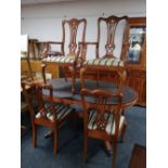 A reproduction yewwood extending table and six chairs