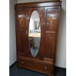 An Edwardian oak mirror door wardrobe