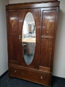 An Edwardian oak mirror door wardrobe