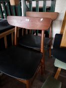 A pair of teak dining chairs.