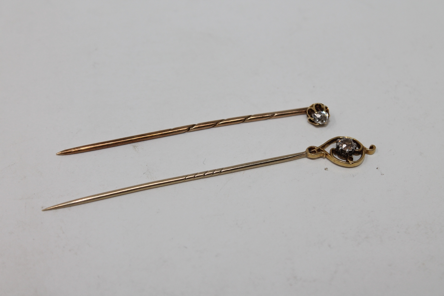 Two antique gold diamond set stick pins, about 0.