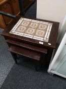 A mid century nest of tiled tables