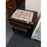 A mid century nest of tiled tables