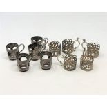 Two sets of five antique silver cup holders.