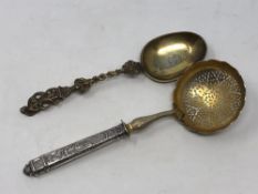 A 19th century silver strainer and a mid-Victorian silver gilt spoon dated 1856 (2)