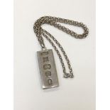 A silver ingot pendant on chain