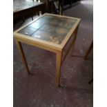 A light oak Scandinavian lamp table with tiled top.