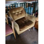 A mid century mustard coloured studded armchair.