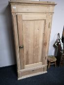 A pine single door cabinet fitted with a drawer