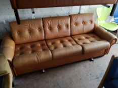 A Scandinavian brown leather two seater studded settee.