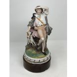 A Continental glazed ware figure : Man and Dog, no marks, on turned wooden base,