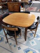 A mid century G-plan teak extending dining table together with a set of four G-plan teak chairs