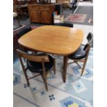 A mid century G-plan teak extending dining table together with a set of four G-plan teak chairs