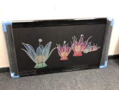 A floral picture in a black frame depicting flowers