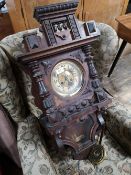 A nineteenth century carved wall clock with pendulum