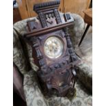 A nineteenth century carved wall clock with pendulum