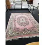 A pink fringed Chinese carpet,