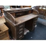 An Edwardian oak roll topped desk