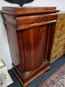 A nineteenth century pine pedestal cabinet fitted with a drawer